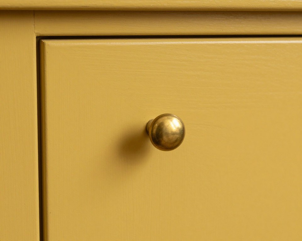 mustard yellow cabinet with antique brass cup pull hardware